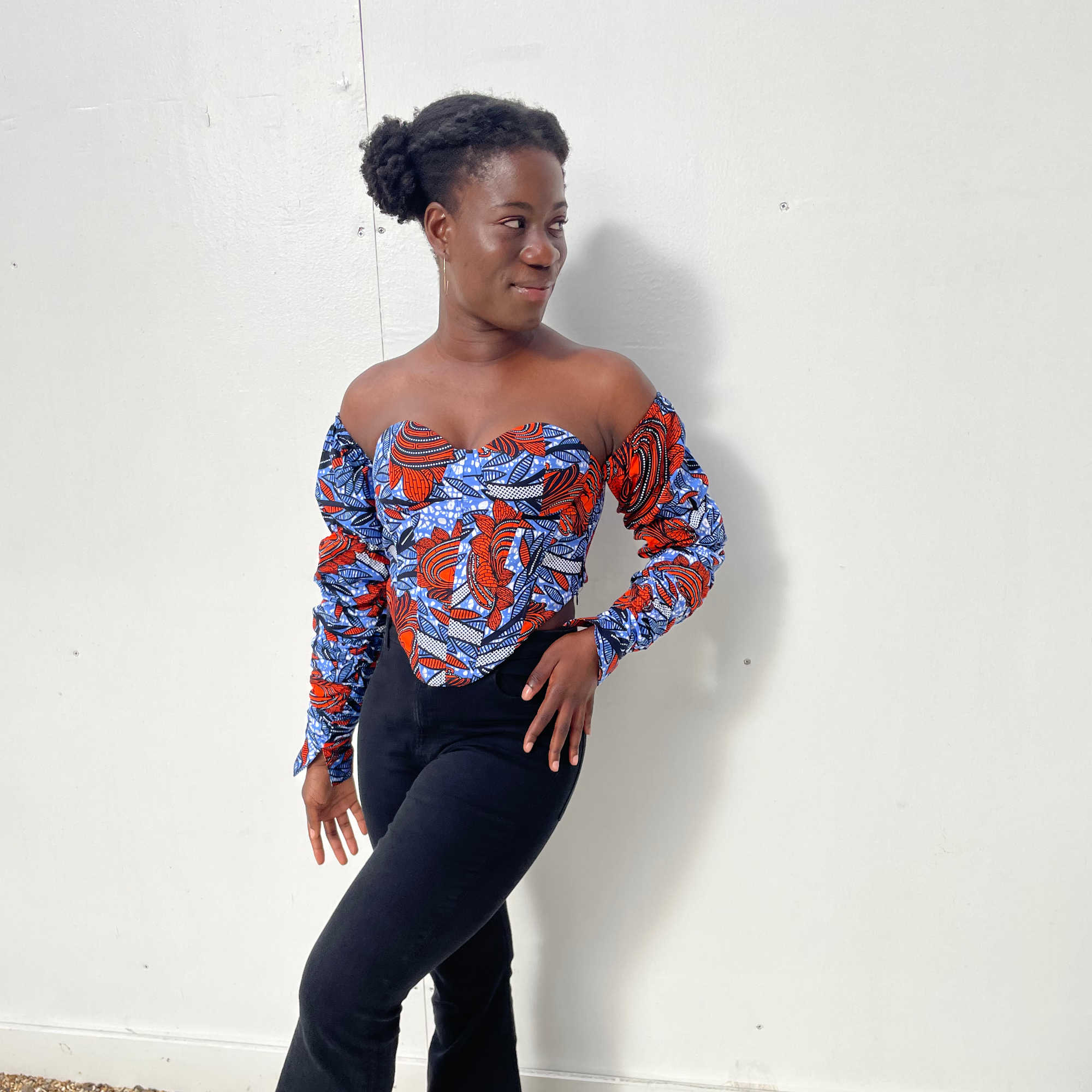 Female model wearing African print corset top with red floral pattern