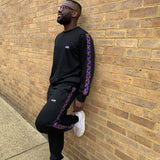 Afro male leaning on wall wearing african print jogger set